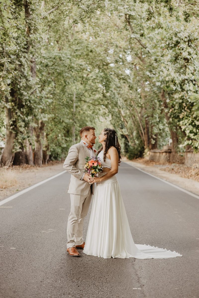 Novios en un camino arbolado